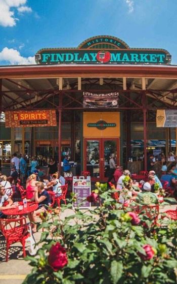 A busy Findlay Market with people sitting at tables and eating.